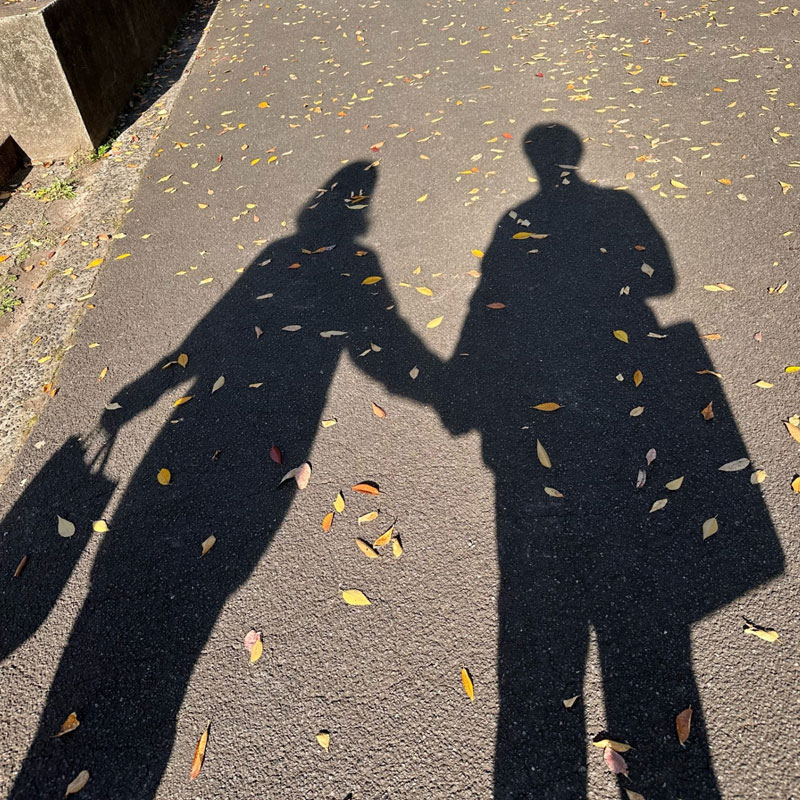 手を繋ぐカップルの影